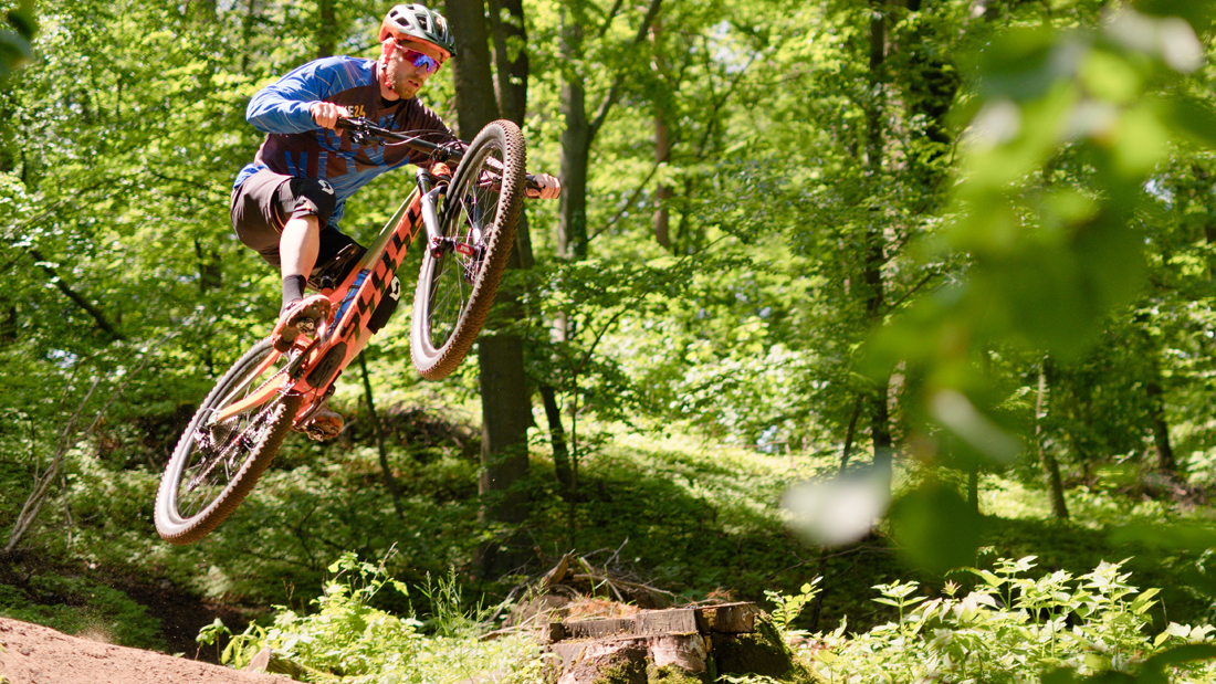 Ciclista in sella a una bici Enduro con abbigliamento dedicato