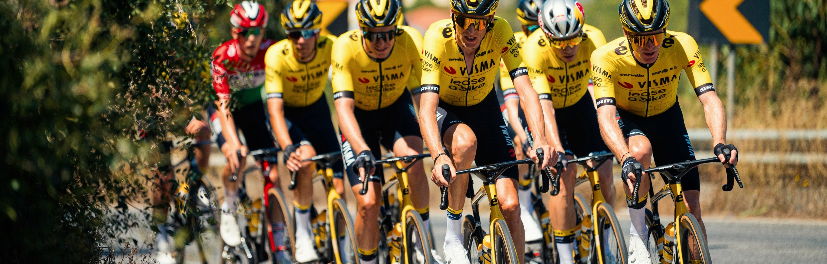 Das Team Visma | Lease a Bike trägt RAPidGEAR Teamkleidung bei einem Straßenrennen in Formation.