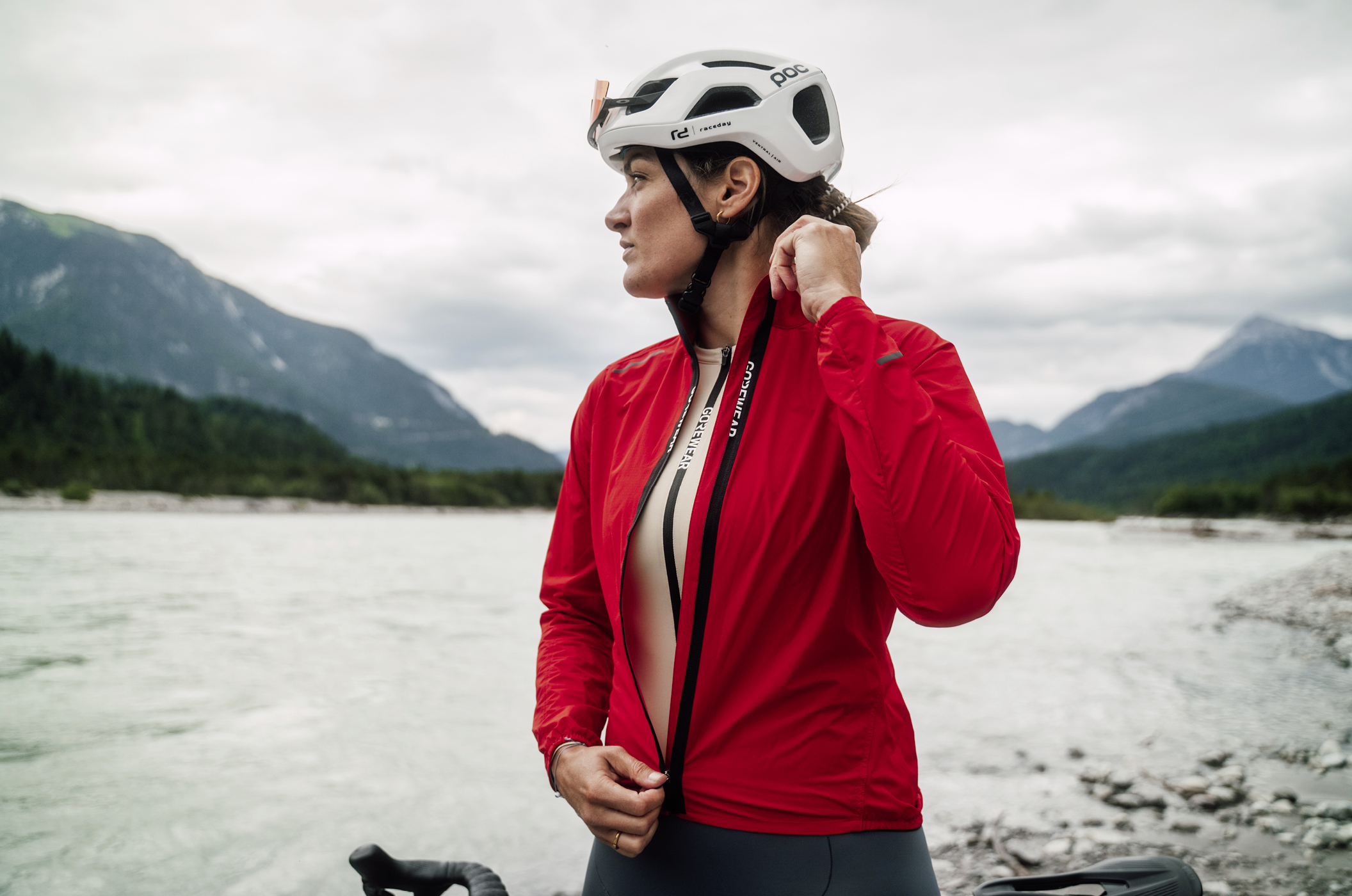 GOREWEAR Spinshift -tuulitakki – täydellinen takki välikauteen Nainen sulkee GOREWEAR Spinshift -tuulitakkinsa vetoketjua.