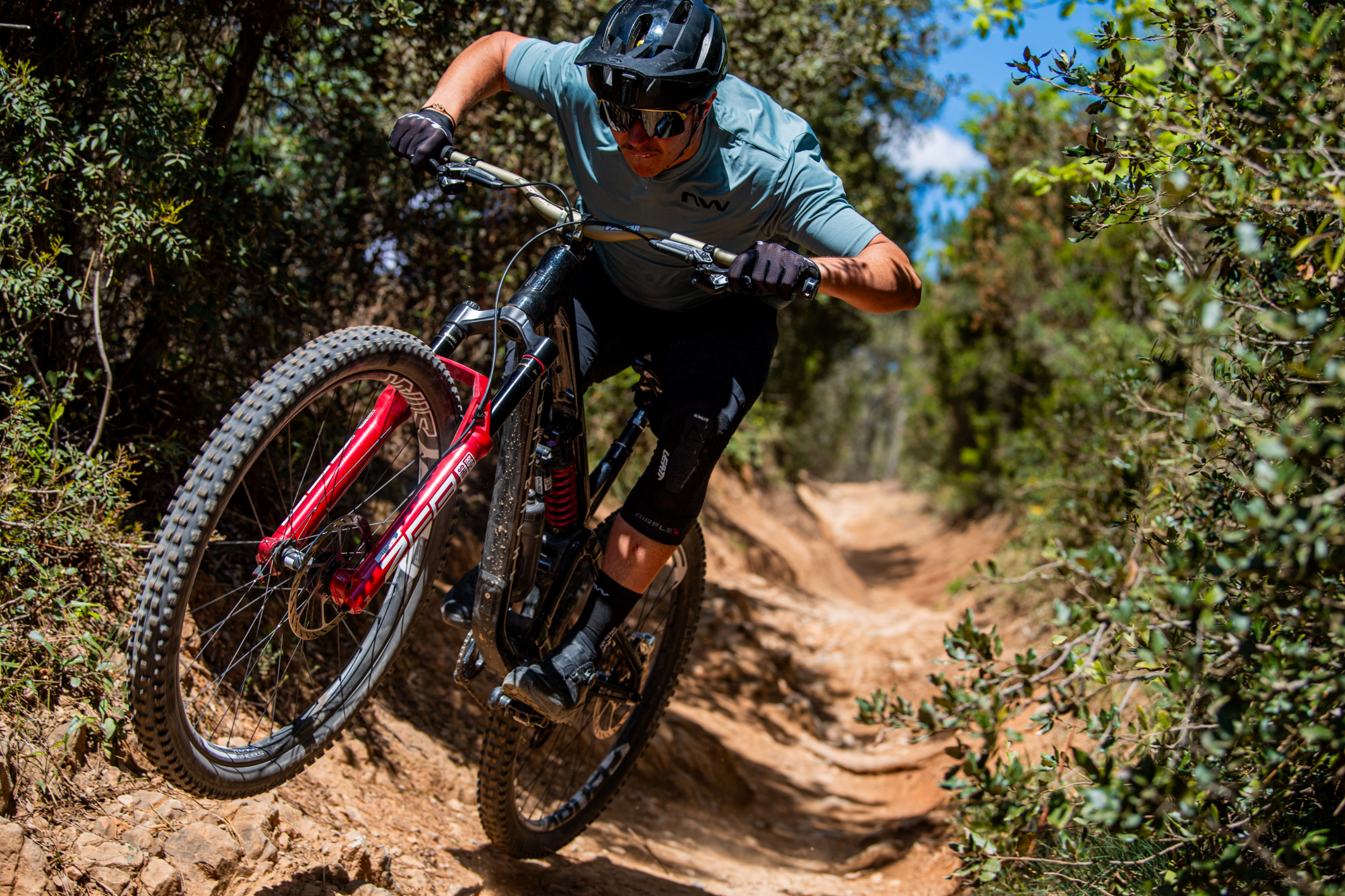 Northwave – huippulaadukkaat MTB- ja maantiepyöräilykengät, ajolasit ja pyöräilyvaatteet Maastopyöräilijä Northwave-varusteissa ajaa vauhdikkaasti haastavalla polulla metsässä.
