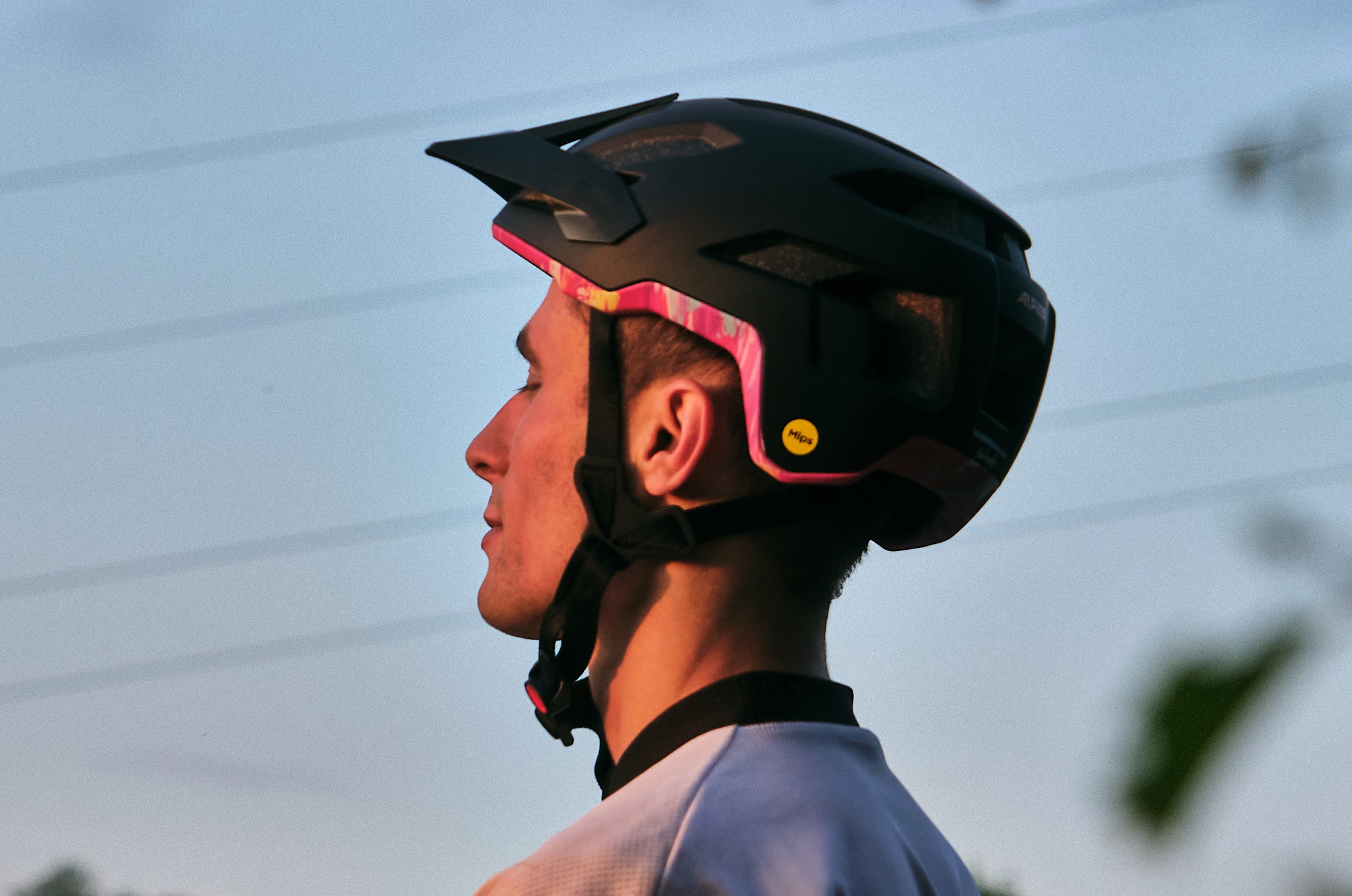 Casques vélo Alpina : Une protection sûre et stylée Casque vélo Alpina avec technologie MIPS de profil sur la tête d'un cycliste à la tombée de la nuit.