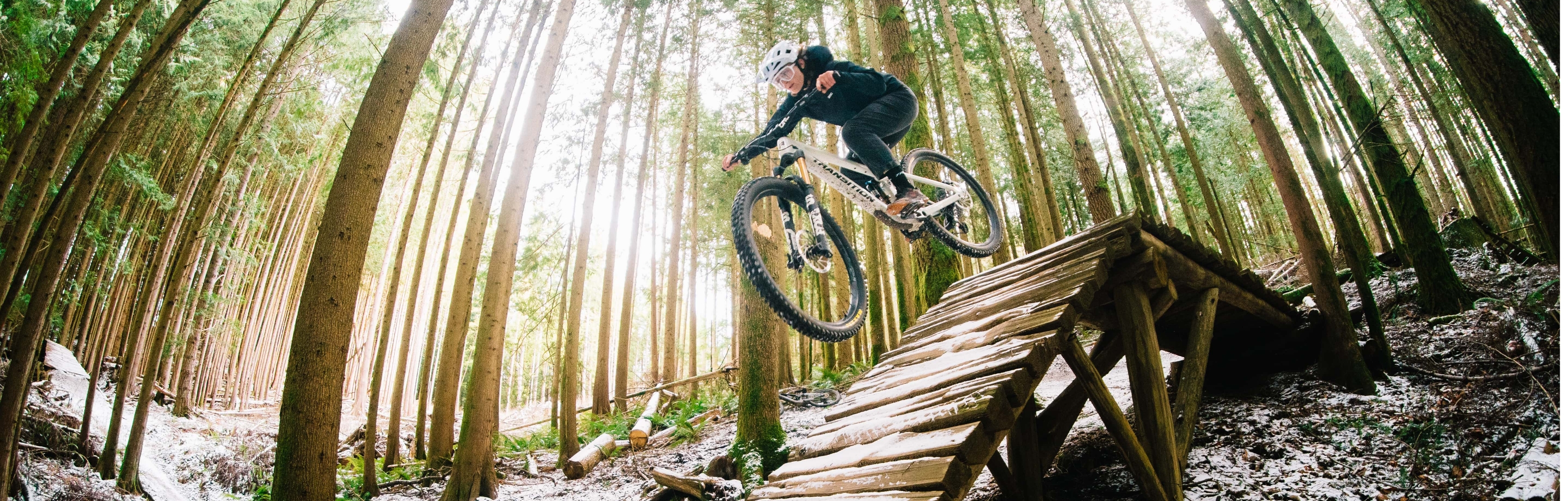 Een vrouw rijdt op een Transition mountainbike over een North-Shore trail.