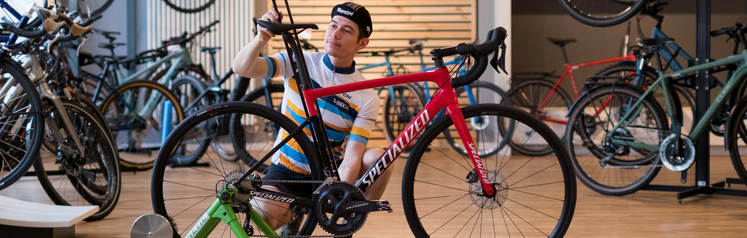 Ein Mann stellt am Rennrad die Sattelhöhe passend ein