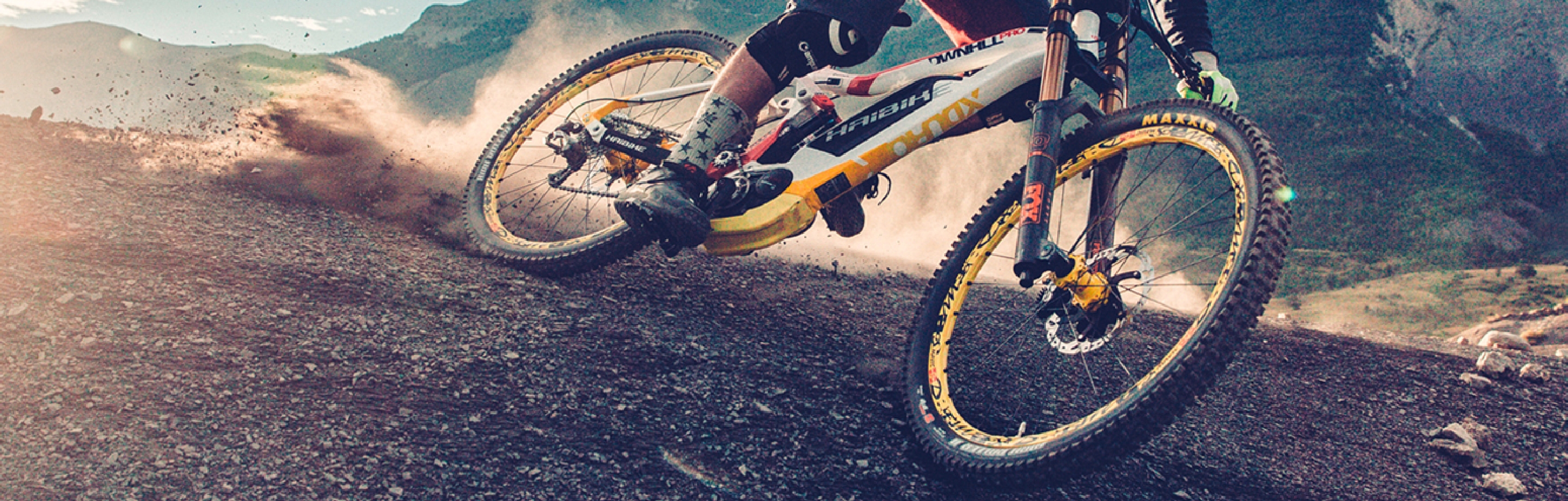 A mountain biker descends at high speed, equipped with a conneX by Wippermann bicycle chain.