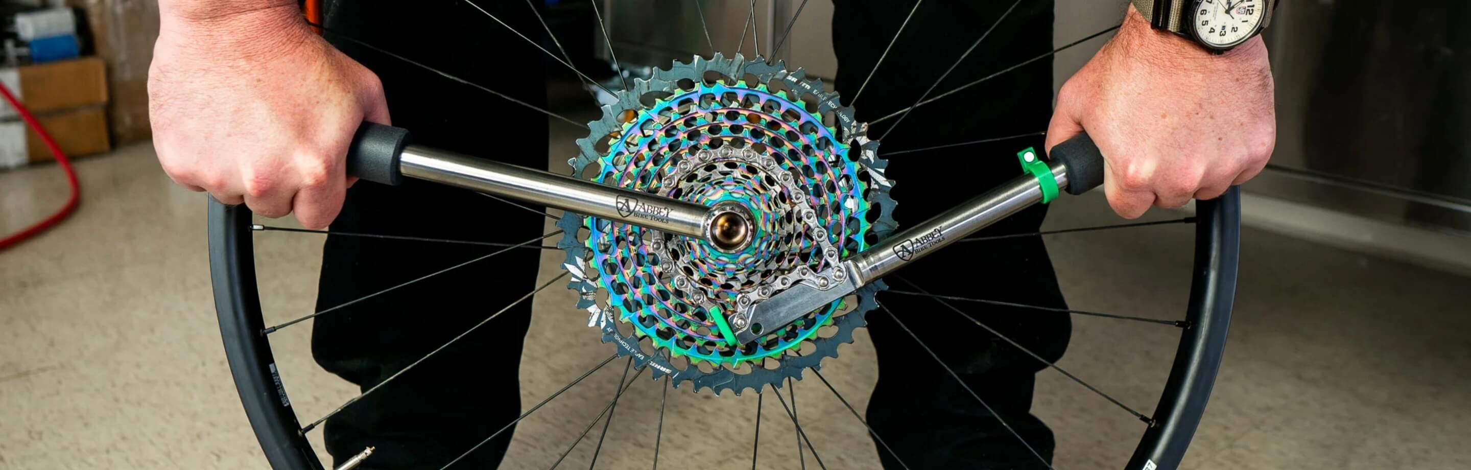 Osoba demontuje kasetę za pomocą narzędzi Abbey Bike Tools.