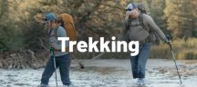 Une femme et un homme portent des sacs à dos Osprey en traversant une rivière lors d'un trek