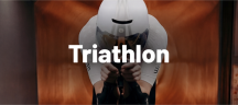 Compressport Triathlonbekleidung und -socken Triathlet in aerodynamischer Haltung auf dem Zeitfahrrad