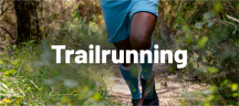 Compressport Laufbekleidung und -socken für Trailrunning Läufer mit Compressport-Wadenstrümpfen auf einem Waldpfad