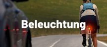 Radfahrerin mit rot leuchtendem Rücklicht auf Straße bei Dämmerung, Kachel Beleuchtung