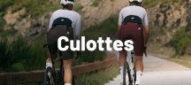 Dos ciclistas de espalda que pedalean por una camino de gravel