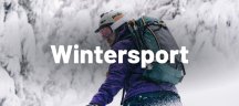 Osprey rugzakken: de ideale uitrusting voor trektochten en reizen Een man in een bos in de winter met een Osprey-rugzak