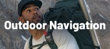 Wanderer mit Rucksack und Garmin GPS-Gerät blickt zum Berg, Kachel Outdoor Navigation