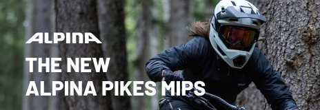 Mountainbikerin mit Alpina Pikes MIPS Fullface-Helm im Wald