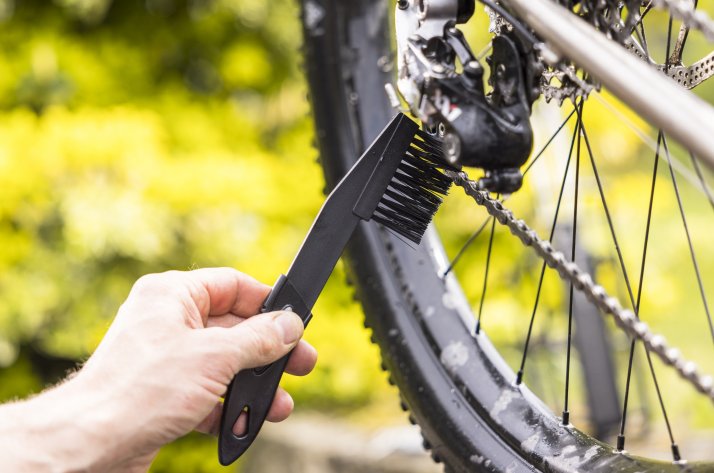 Detailaufnahme bei der Reinigung eines Fahrradantriebs mit einer Bürste Detailaufnahme bei der Reinigung eines Fahrradantriebs mit einer Bürste