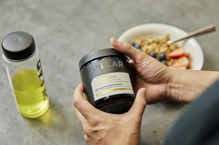Pillar Performance Ultra Immune C wird als Teil einer ausgewogenen Morgenroutine mit Frühstück und Getränk gezeigt.
