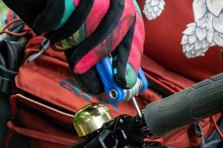 Fahrrad-Multitools – Die Alleskönner für unterwegs Ein Radfahrer zieht die Schraube an einem Griff an.