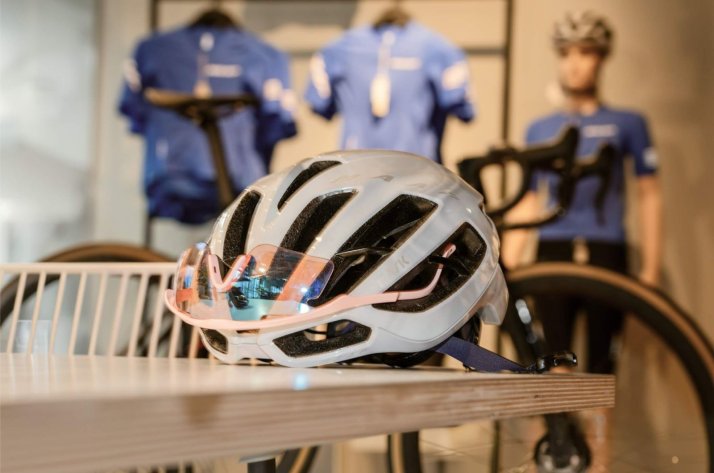Cascos de bicicleta de carretera: aireados, rápidos y con estilo Casco de ciclismo en una mesa y con unas gafas de ciclismo en una tienda de ciclismo de BIKE24