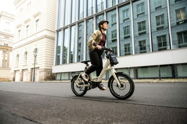 A woman rides her QiO e-bike through the city