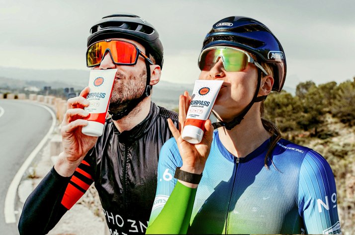 What drives SURPASS – sports care developed by athletes Two cyclists holding SURPASS cream after a ride
