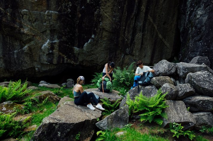 Een groep klimmers tijdens een pauze in het bos, bezig met hun Mammut klimuitrusting.