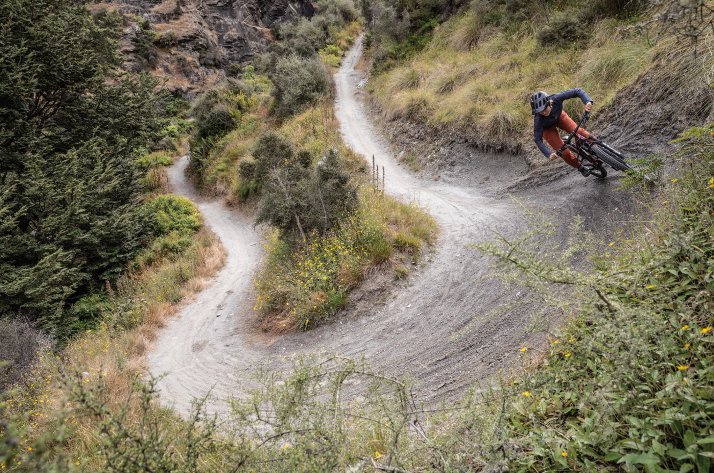 Patagonia MTB-kleding - Built clean. Ridden dirty. Een mountainbiker stuurt scherp door een stoffige haarspeldbocht, gekleed in Patagonia-fietskleding.