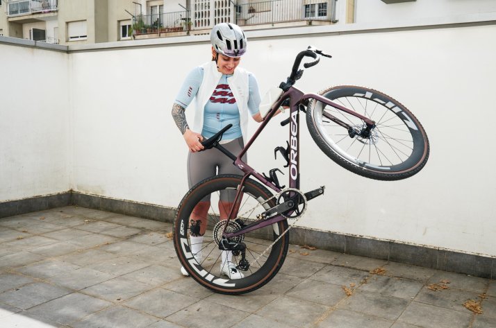 A cyclist in MAAP gear, carrying their bike