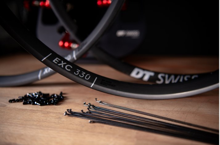  Szprychy i nyple DT Swiss oraz obręcze EXC 330 przygotowane do zaplotu na stole.