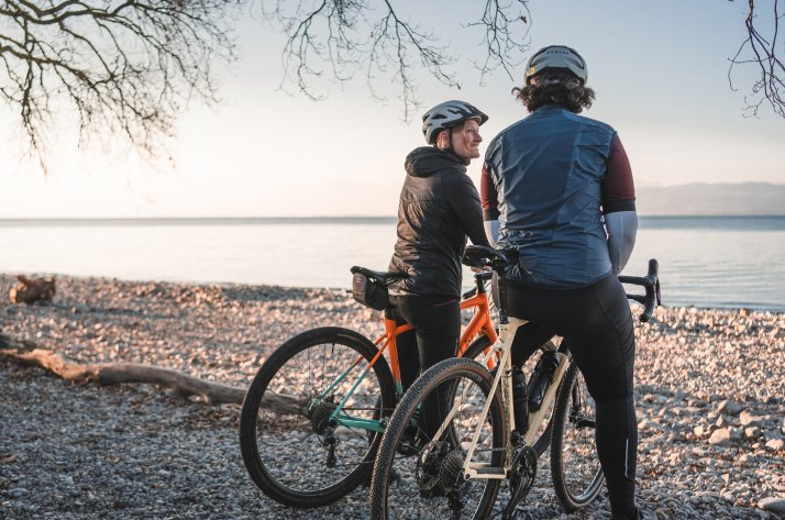 VAUDE „ReCycle“ bike bags Two gravel riders with VAUDE gear take a break on a pebble beach by a lake