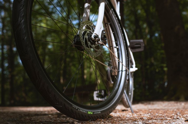 Continental City, Trekking & E-Bike Fahrradreifen: CONTACT - Ein Name für alle Anforderungen & Einsatzbereiche Continental Alltagsreifen PureContact auf festem Waldboden unter einem Trekkingrad.