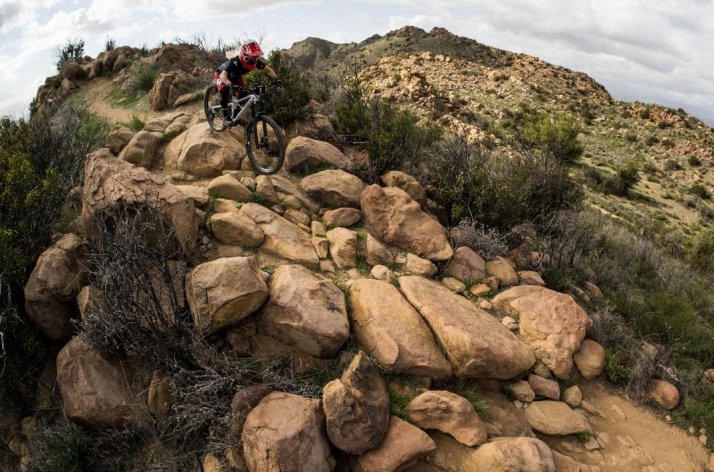 Ciclista en bicicleta de montaña bajando por una camino de rocas