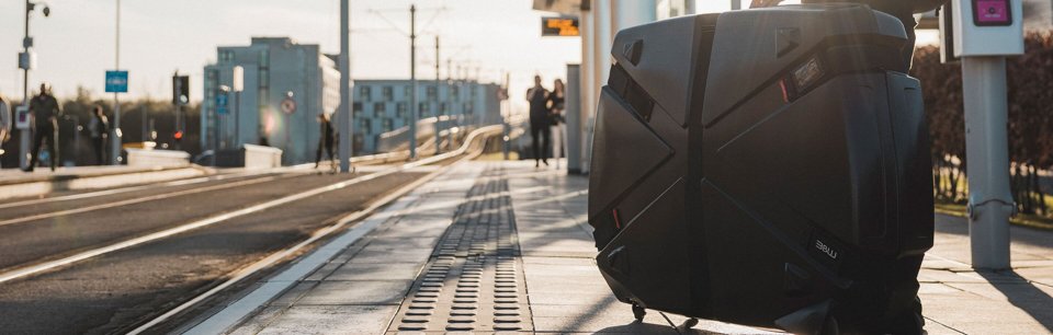 Maleta de bicicleta rígida apoyada en el suelo en una parada de autobús