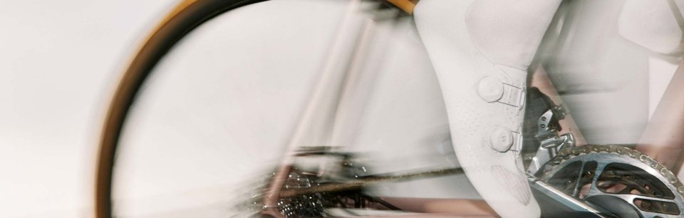 Piede con calzino e scarpa bianca su un pedale