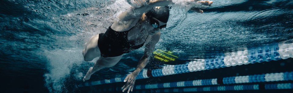 Toma bajo el agua de una atleta en movimiento con gafas de natación FORM.