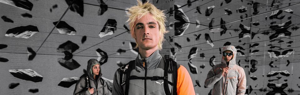 Vêtus de vêtements techniques Salewa, trois aventuriers se tiennent avec assurance dans un décor de roche artistique.