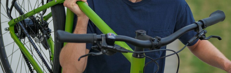 Persona che trasporta su una spalla la bici