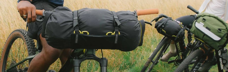 Fahrräder mit Wholegrain Cycles Bikepacking-Lösungen am Lenker zeigen großzügigen Stauraum und Stabilität für Offroad-Abenteuer.