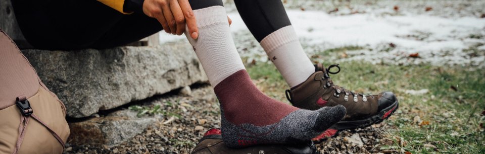 Persona colocándose un calcetín Falke de trekking