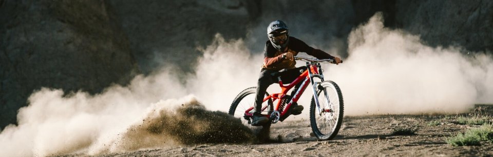 Un pilote de VTT dérive à travers un paysage poussiéreux, aidé par les freins Trickstuff.