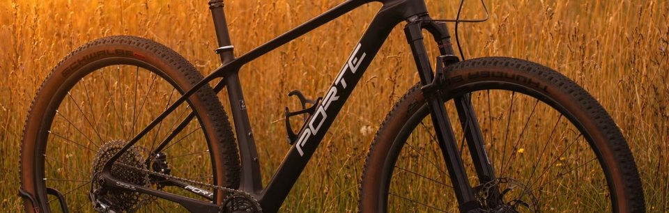 Ein MTB mit Porte Atlas Carbon Rahmen und Laufrädern vor einem Kornfeld