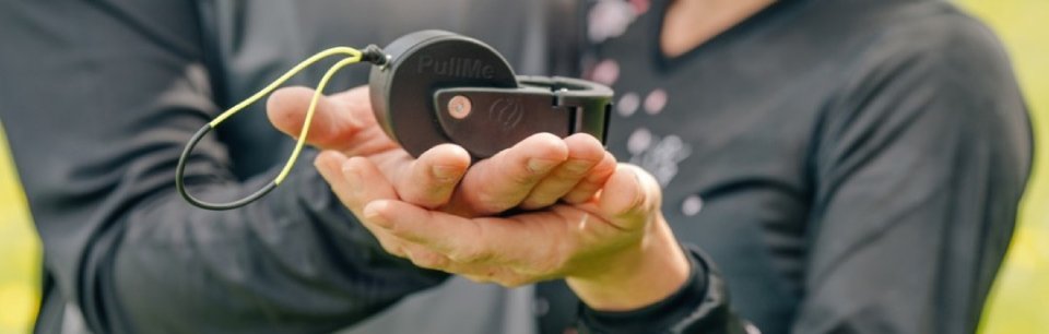 Deux personnes tiennent ensemble l'outil d'urgence PullMe de Ensemble & Dehors dans leurs mains.