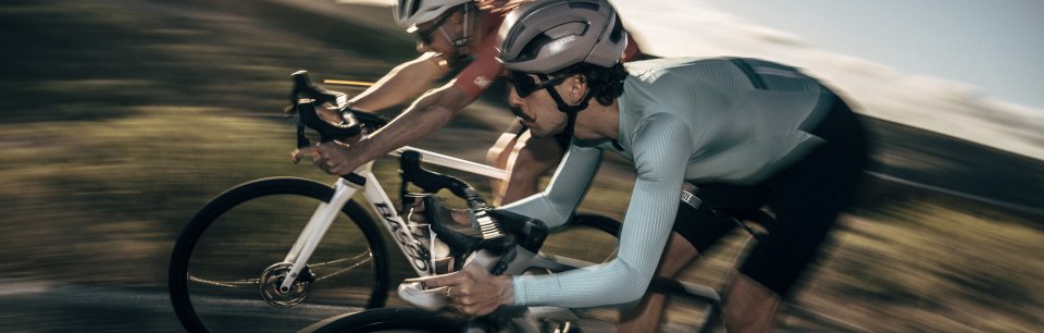 Dos ciclistas en la carretera con ropa de ciclismo de Café du Cycliste