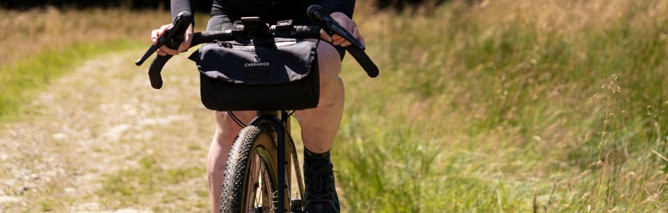 Persona in bici con una borsa Carradice anteriore