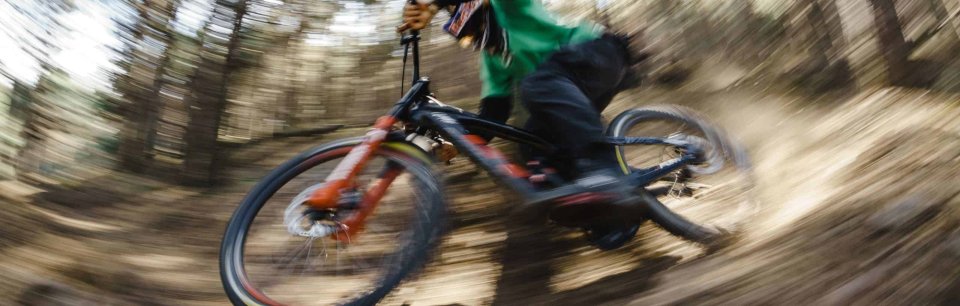 Conduite dynamique à travers la forêt sur un VTT équipé de pièces Burgtec pour vélos.