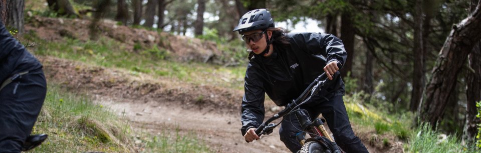 Ciclista con gafas y casco de ciclismo Alpina bajando por una montaña