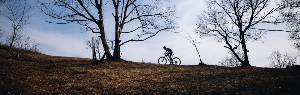 Ein Rennradfahrer auf weiter Landschaftsaufnahme symbolisiert Ausdauer und Komfort der Crono Schuhe für ambitionierte Cyclists.