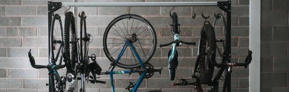 Soporte de bicicletas colgado en el techo mediante ganchos y un perfil principal