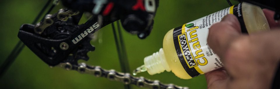 Mano che applica del lubrificante sulla catena 