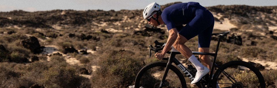 Ein Mann in Rennradkleidung fährt auf dem Asphalt.