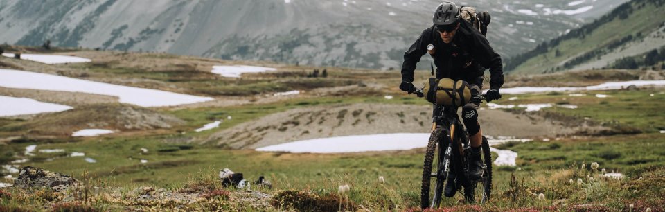 A cyclist in Fox Racing gear riding through the mountains