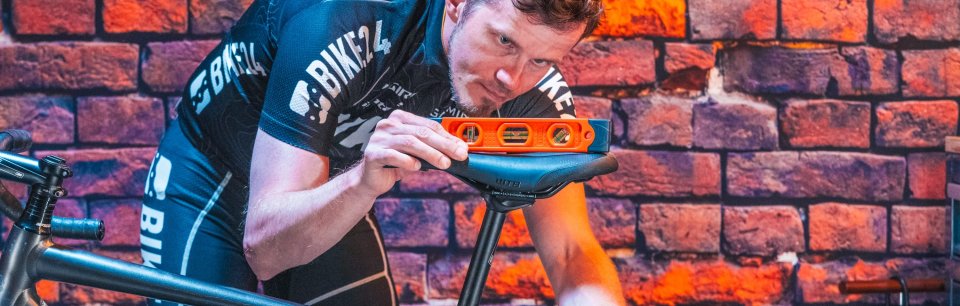 Ein Mann stellt am Rennrad die Sattelhöhe passend ein